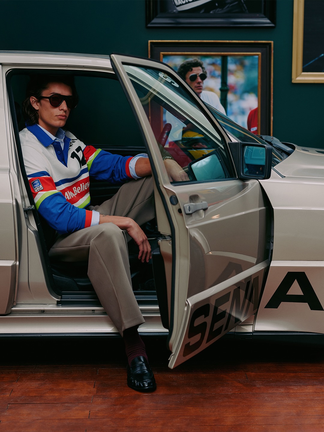 Modelo com camisa listrada da coleção Zara x Senna dentro de um Mercedes com o nome Senna