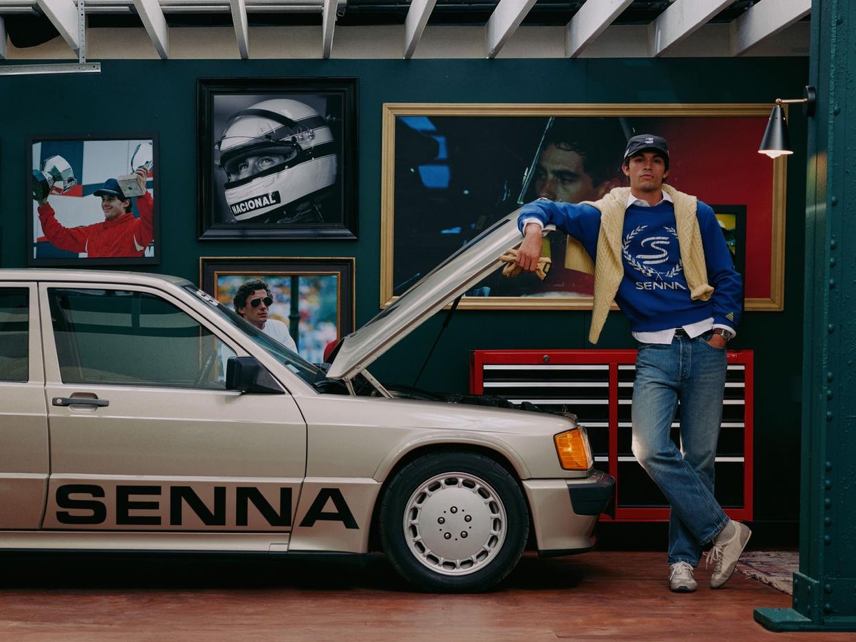 Modelo com moletom azul da coleção Zara x Senna ao lado de um Mercedes com o nome Senna
